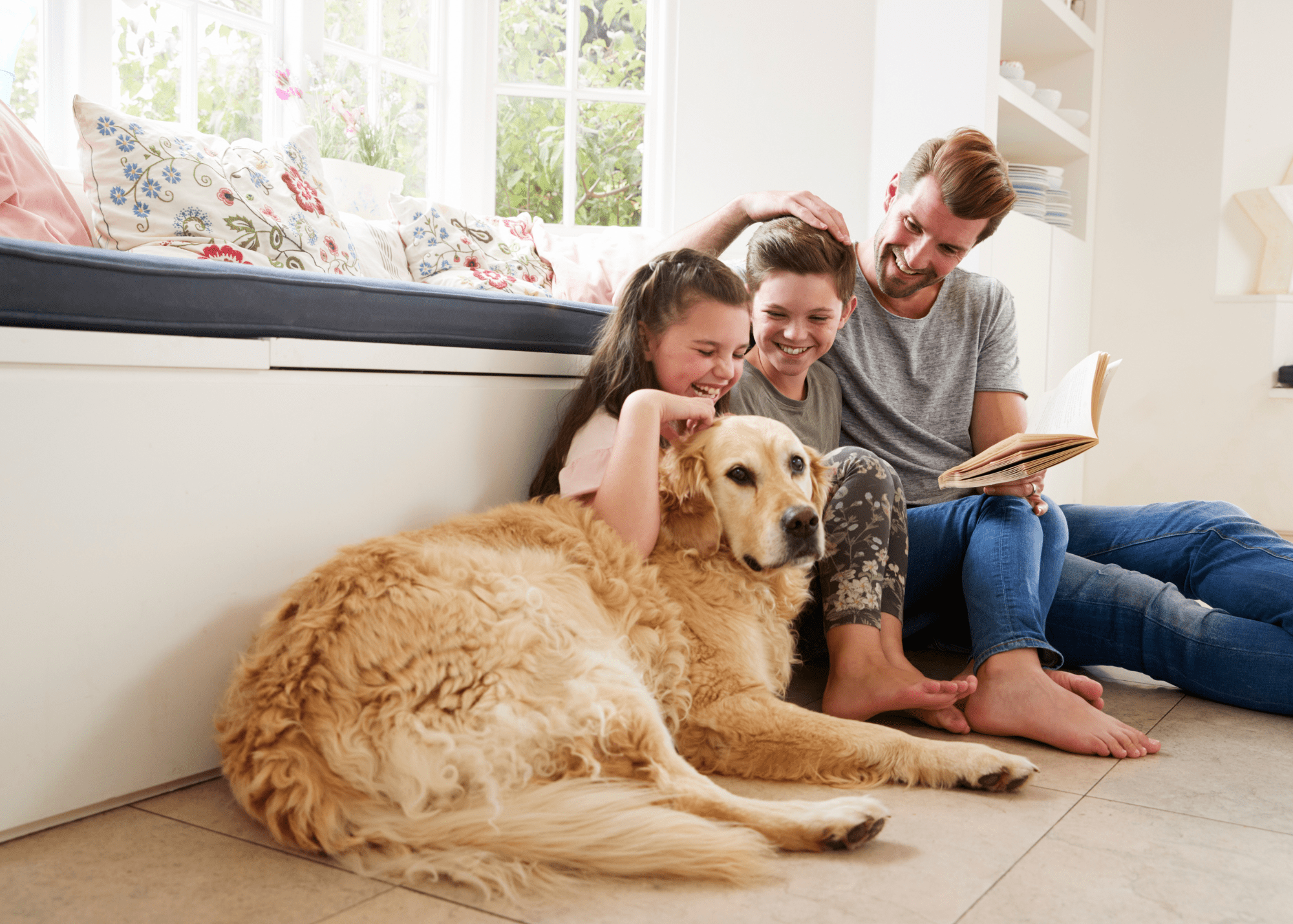 a family sits on the floor with their dog