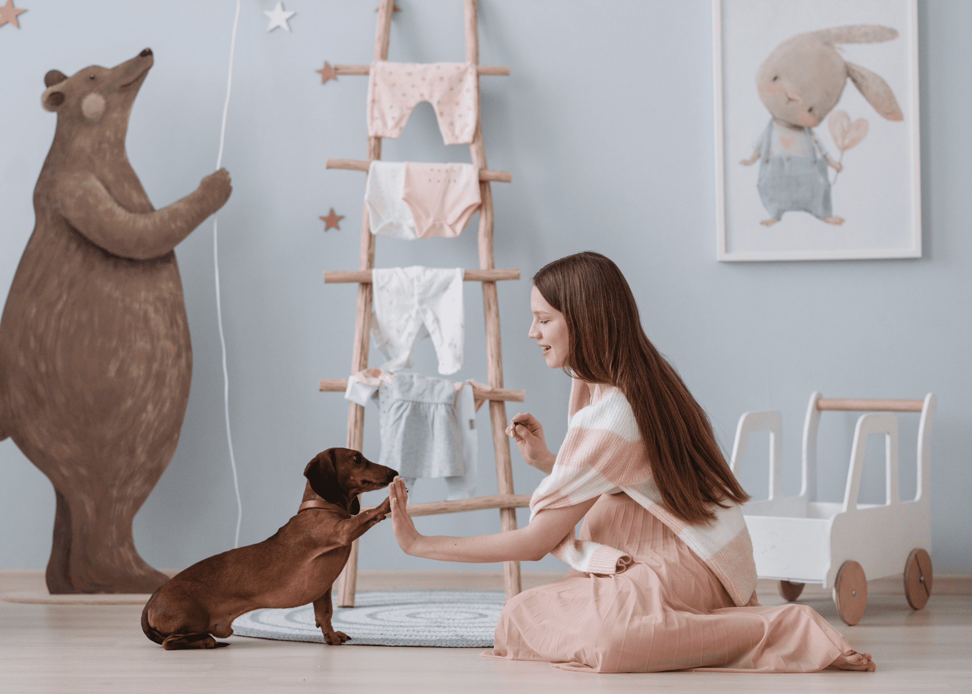 An expecting mom trains her little dog treats in the baby's nursery